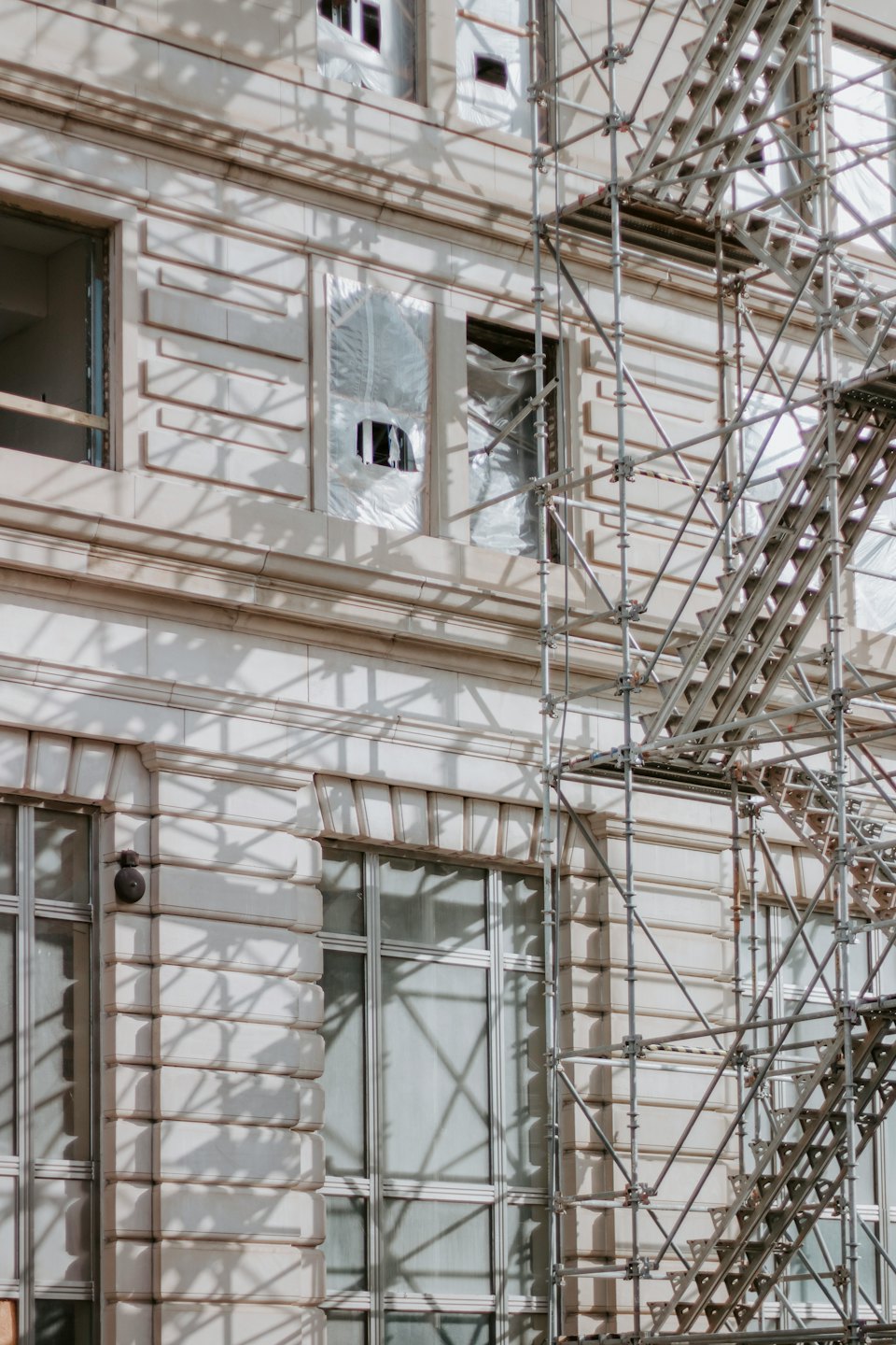 Impalcatura metallica circonda un edificio in pietra in costruzione.