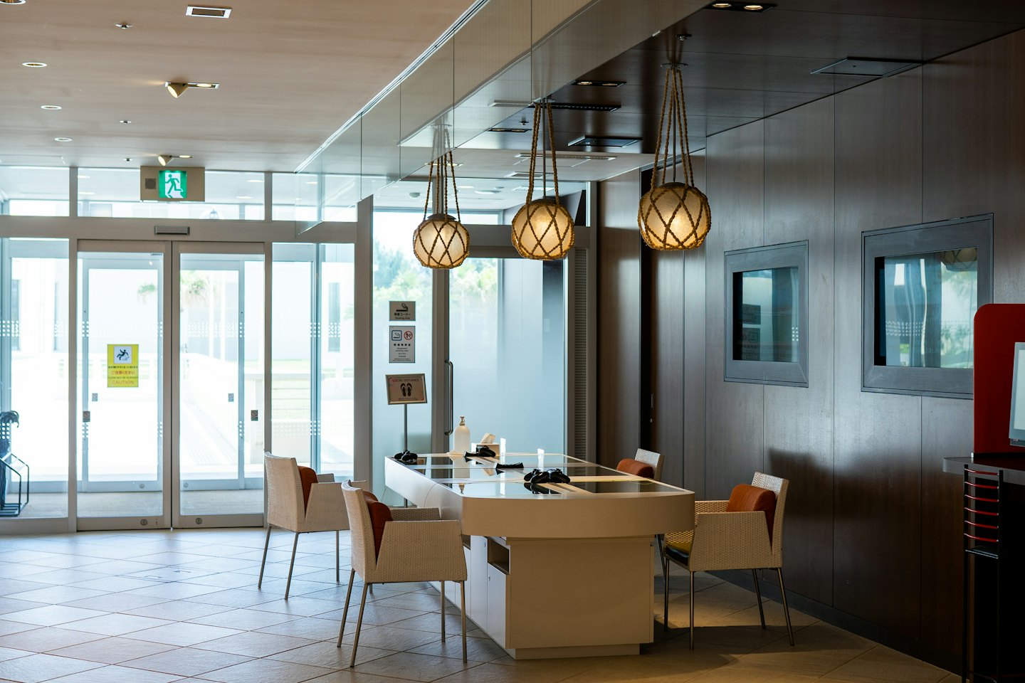 Moderna reception con luci a globo e parete in legno.
